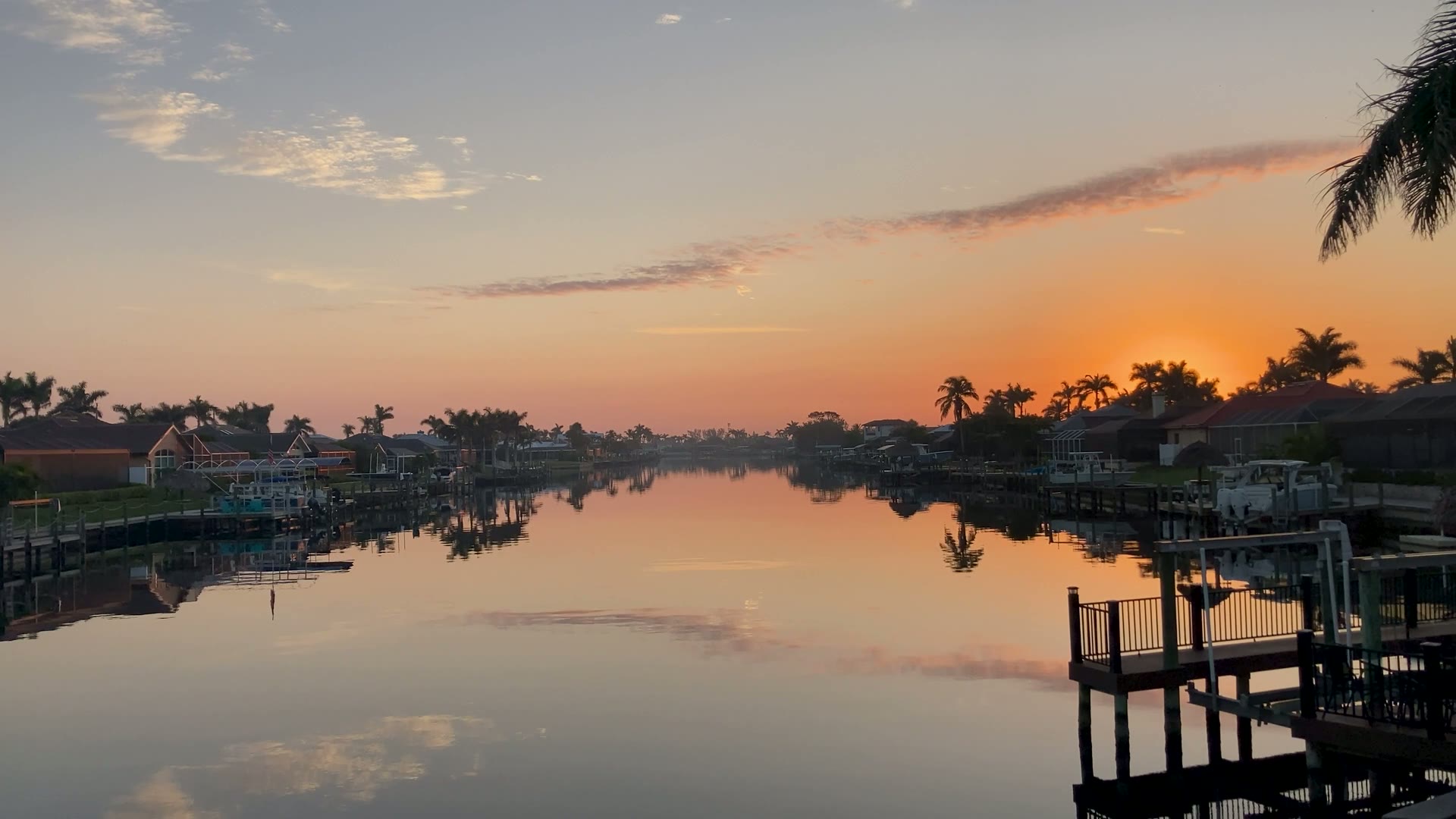 Sunrise over a palm-lined canal waterway in Cape Coral, Florida