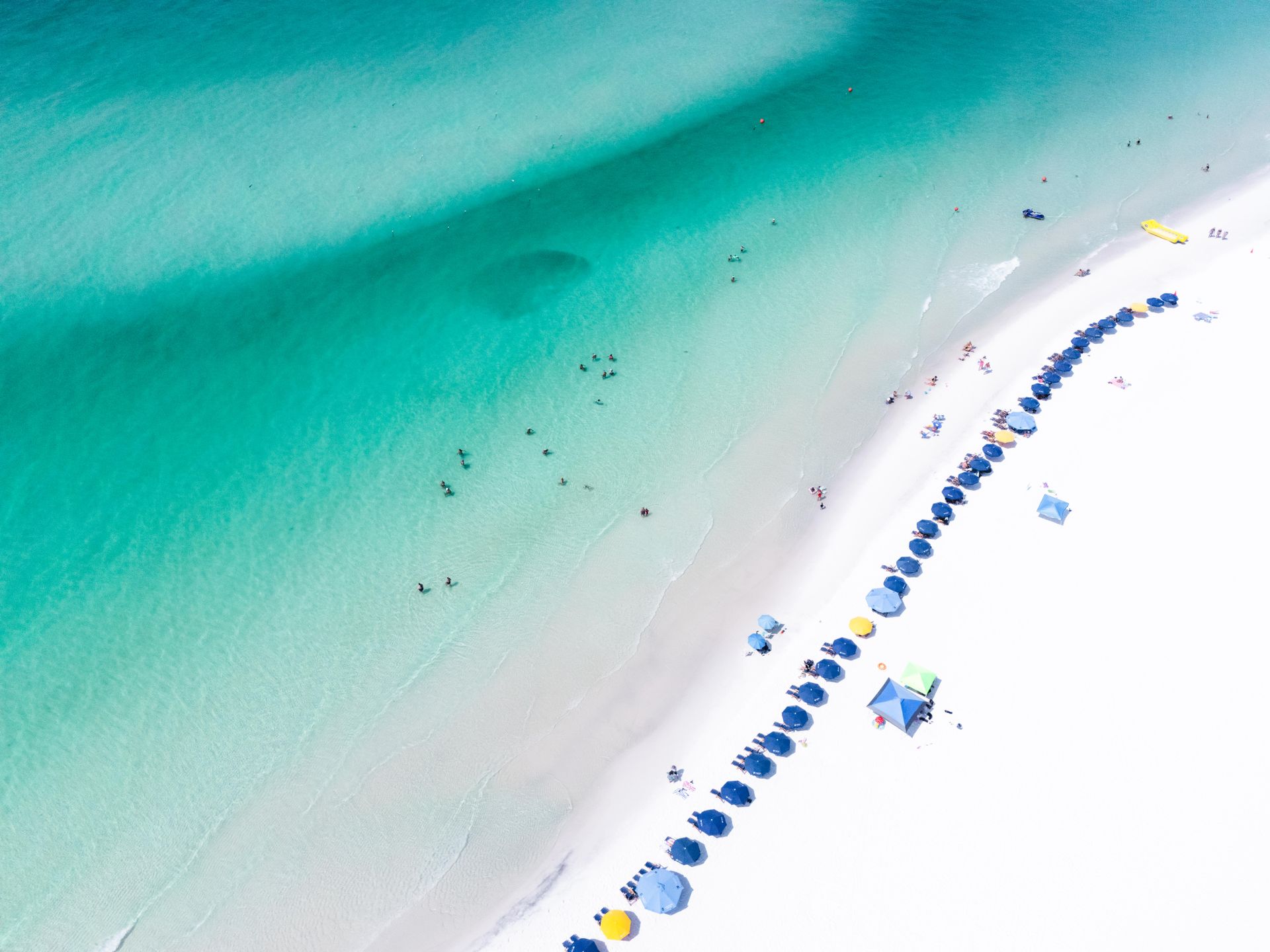 Aerial view of white sand and turquoise Gulf water with beach umbrellas at Miramar Beach, Florida (photo: Sean Thomas, Pexels)