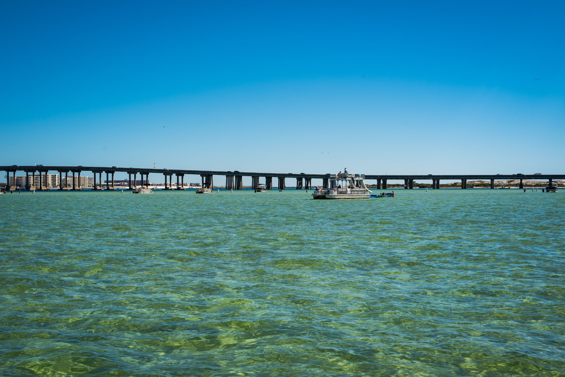 Boats anchored in clear emerald water near the Destin bridge, Emerald Coast, Florida (photo: Chris F, Pexels)